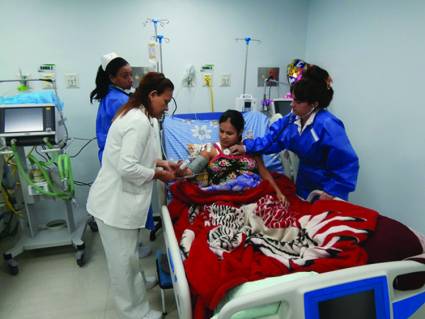Paciente venezolana; al fondo, enfermera local; a los lados, enfermera y doctora cubana. La obra se llama Solidaridad.