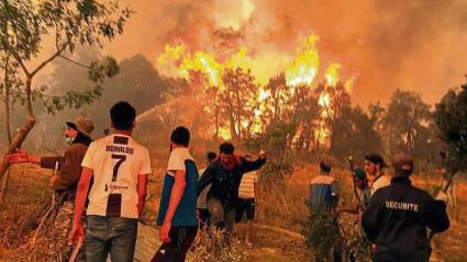 Vecinos de un pueblo cercano a Tizi Uzu, tratan de detener el incendio