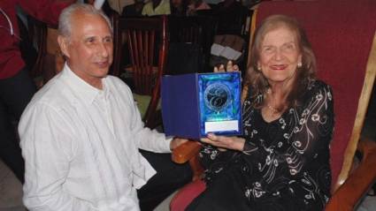 Mtz Carilda Oliver recibe premio de manos de José Carlos de Santiago.