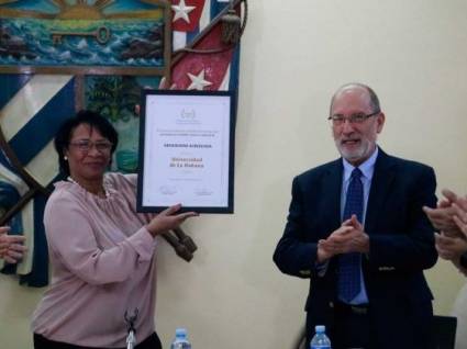 a Dra. Miriam Nicado, rectora de la UH, recibe el reconocimiento