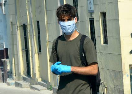 Joven usando guantes y nasobuco