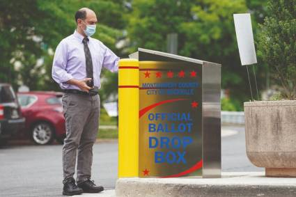 Un ciudadano depositando su voto en el correo