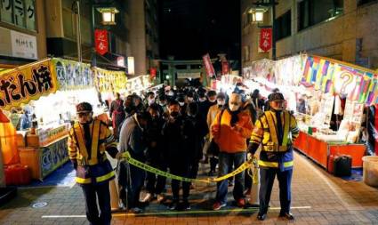 Grupos de personas usando mascarillas esperan en el frontis del templo Kanda Myojin para rezar por el nuevo año en Tokio