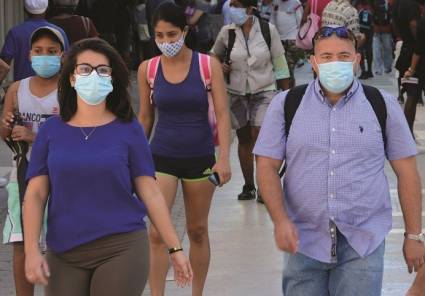 Personas caminan por la calle usando nasobuco