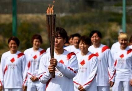 Azusa Iwashimizu, futbolista de la selección japonesa, llega con la antorcha olímpica a un punto de relevo en un centro de entrenamiento de Naraha, en la prefectura de Fukushima