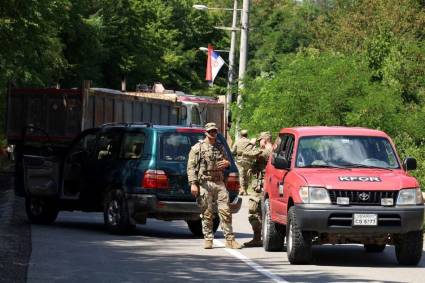 Soldados de la OTAN que prestan servicio en Kosovo patrullan junto a una barricada en la carretera levantada por serbios étnicos cerca de la ciudad de Zupce.