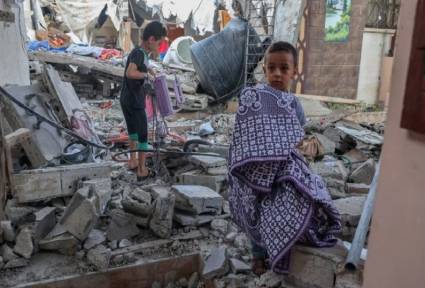 Ninos palestinos tratan de rescatar sus pertenencias