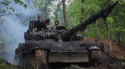 Soldados ucranianos en un tanque recorren la carretera hacia sus posiciones en Donbass