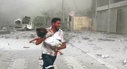Un médico corre con un niño herido en el bombardeo a Gaza