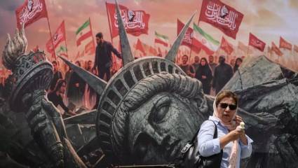 Una iraní pasa junto a cartel contra la agresión estadounidense en Teherán.